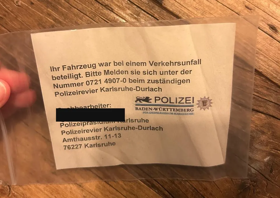 Hinweiszettel des Polizeireviers Karlsruhe-Durlach in einer Klarsichthülle, Name des Sachbearbeiters geschwärzt